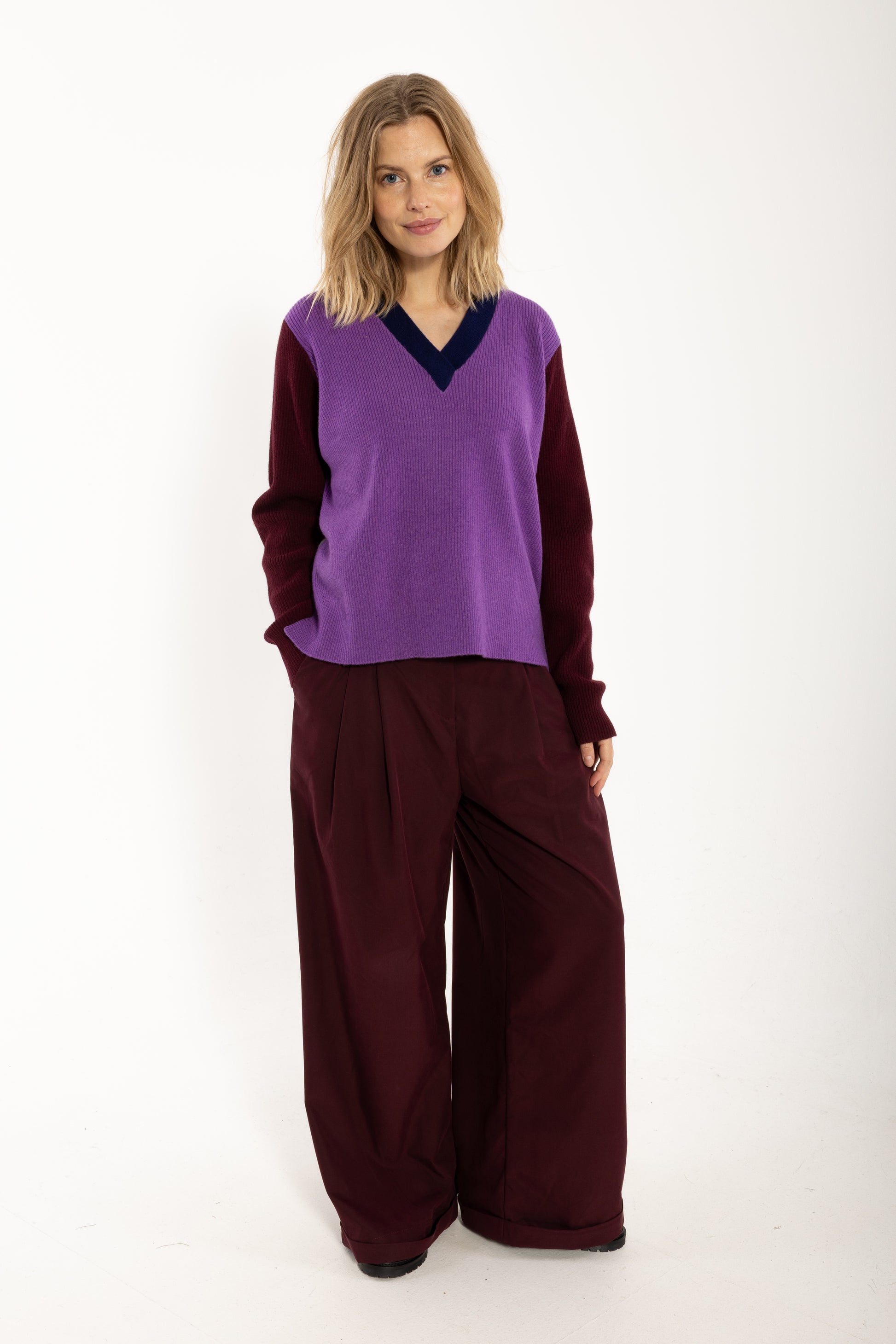 Locer und gerade geschnittener Pullover im Colourblock Design mit bordeaux Ärmeln, grau Rückenteil und fresh lila Front aus feinster Merinowolle.