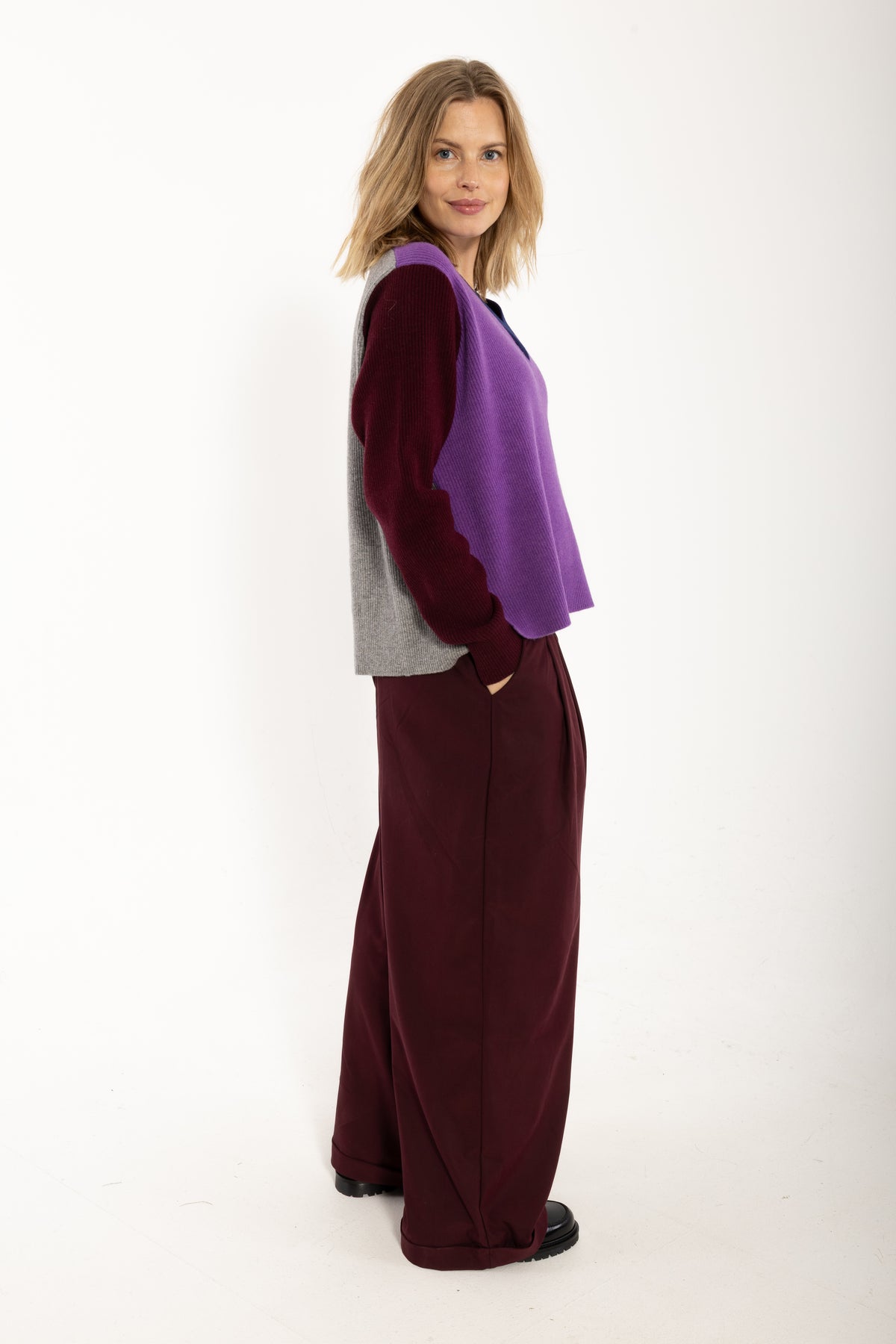 Locer und gerade geschnittener Pullover im Colourblock Design mit bordeaux Ärmeln, grau Rückenteil und fresh lila Front aus feinster Merinowolle.