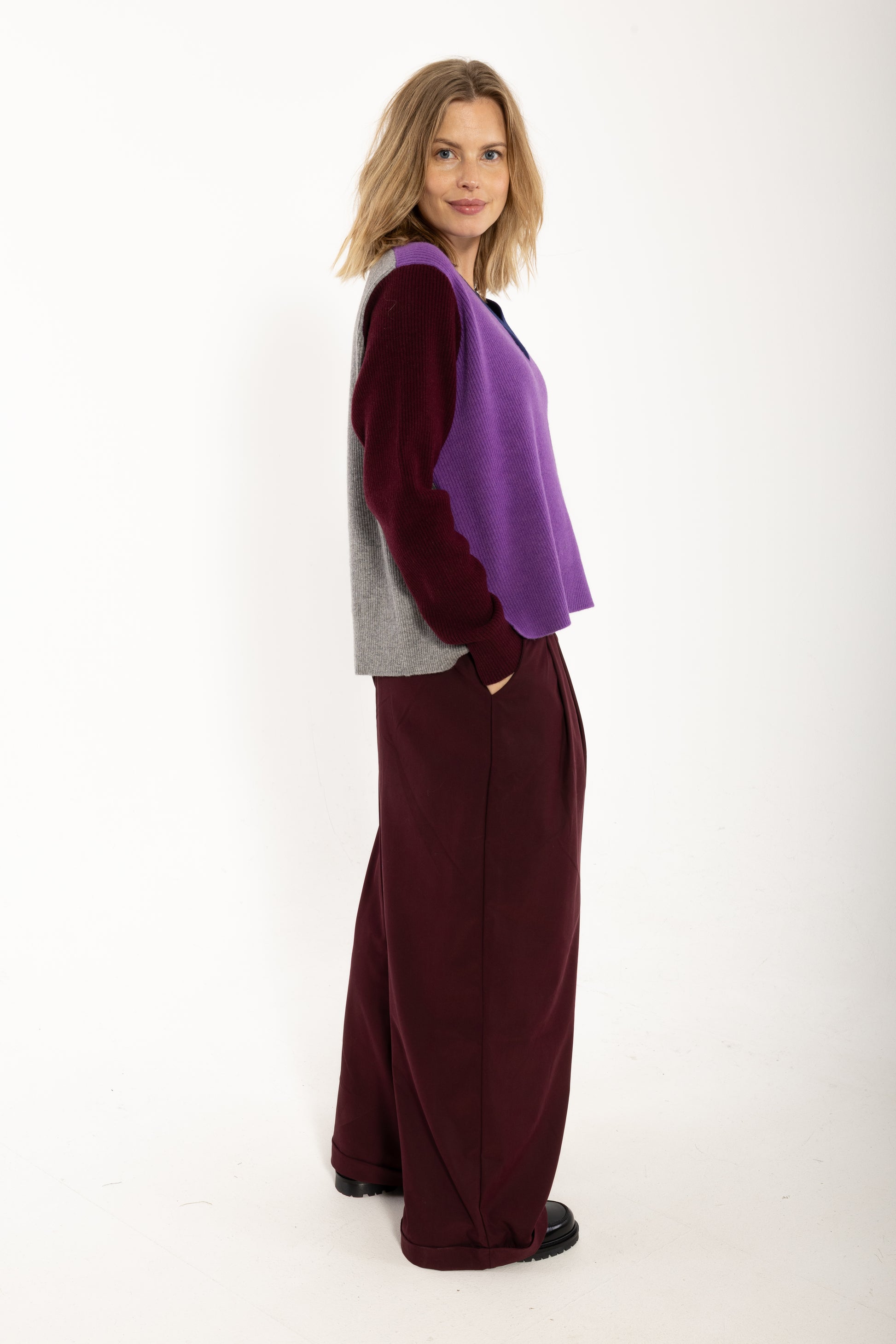 Locer und gerade geschnittener Pullover im Colourblock Design mit bordeaux Ärmeln, grau Rückenteil und fresh lila Front aus feinster Merinowolle.
