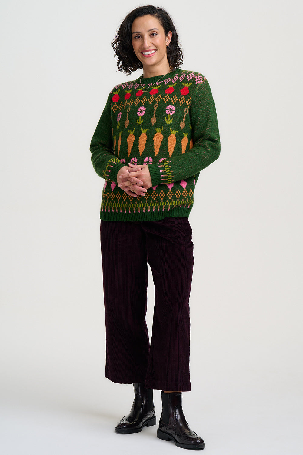 Strickpullover in dunklem Grün mit buntem Gmüse in Fairisle Stickreihen, Möhren, Radiesschen und Rüben, sowie Spaten und Blümchen reihen sich aneinander im witzigen Bauernhof Spirit.