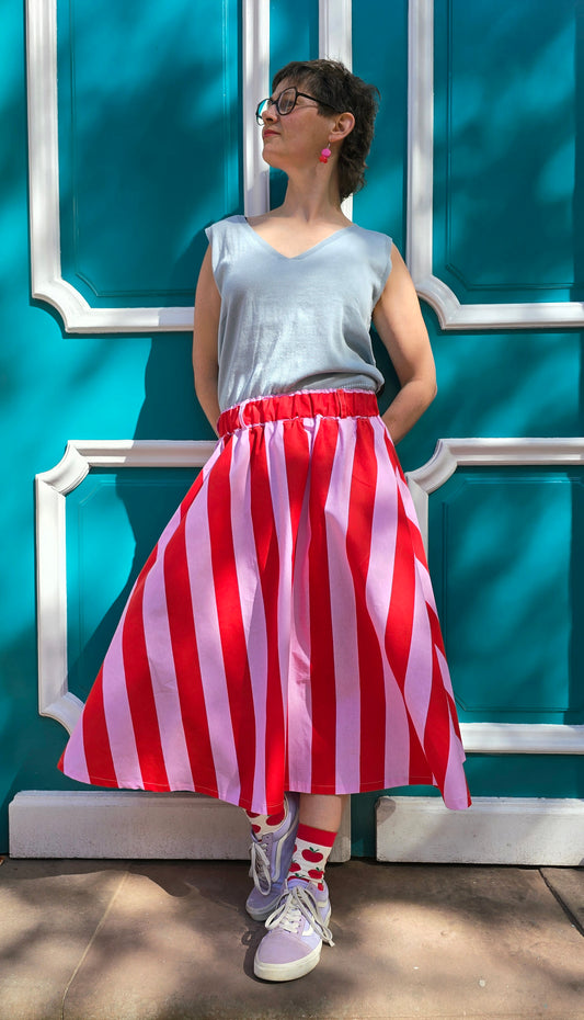 Gestreifter, ausgestellter,schwingender Rock mit Blockstreifen in rosa und rot, seitlichen Eingrifftaschen.