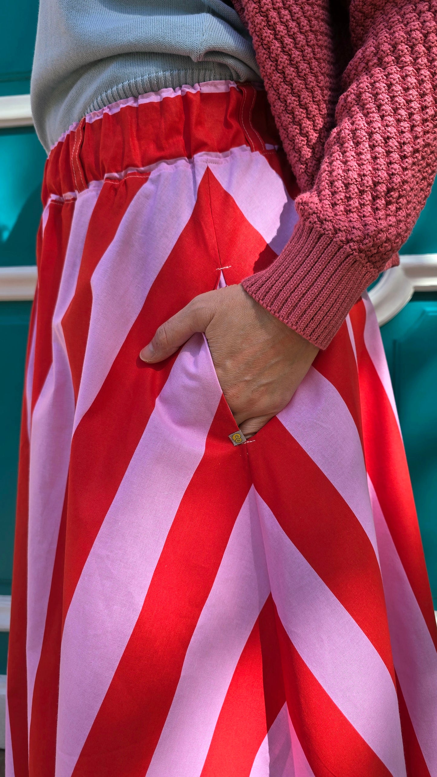 Gestreifter, ausgestellter,schwingender Rock mit Blockstreifen in rosa und rot, seitlichen Eingrifftaschen.