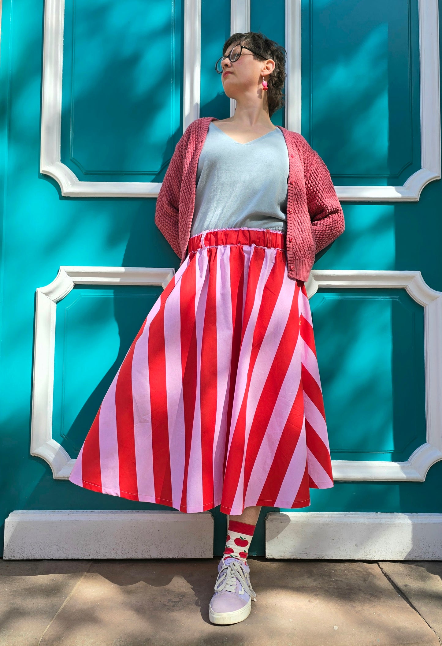 Gestreifter, ausgestellter,schwingender Rock mit Blockstreifen in rosa und rot, seitlichen Eingrifftaschen.