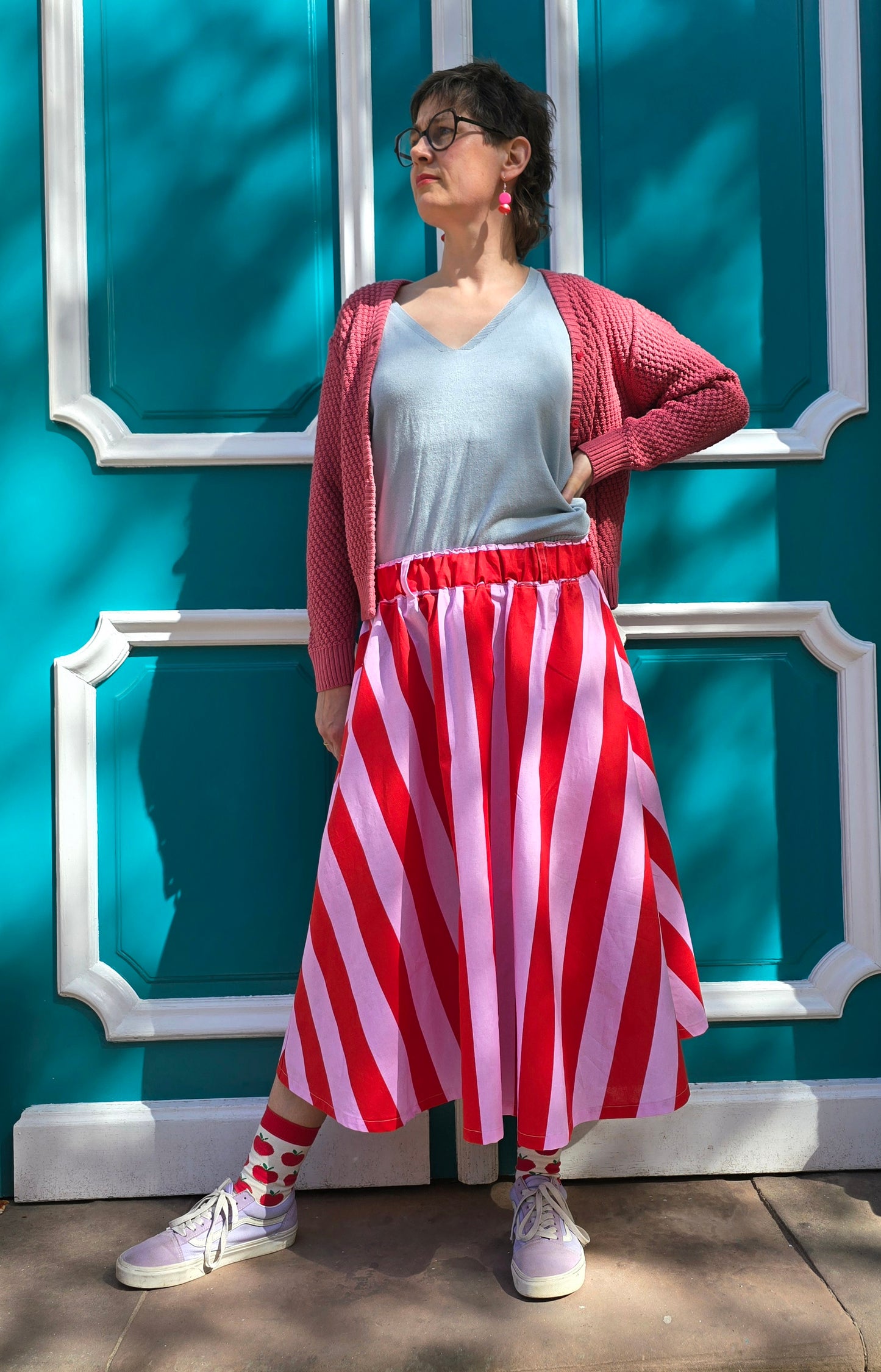 Gestreifter, ausgestellter,schwingender Rock mit Blockstreifen in rosa und rot, seitlichen Eingrifftaschen.