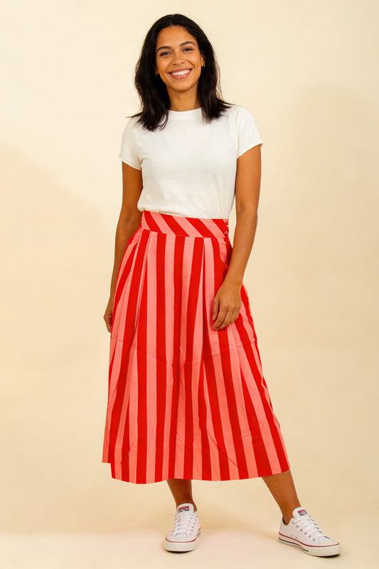 Wadenlanger, ausgestellter Rock mit glatter Taille und Rockteil in Falten gelegt, großzügige Blockstreifen in rot und pink, sommerlich frisch.