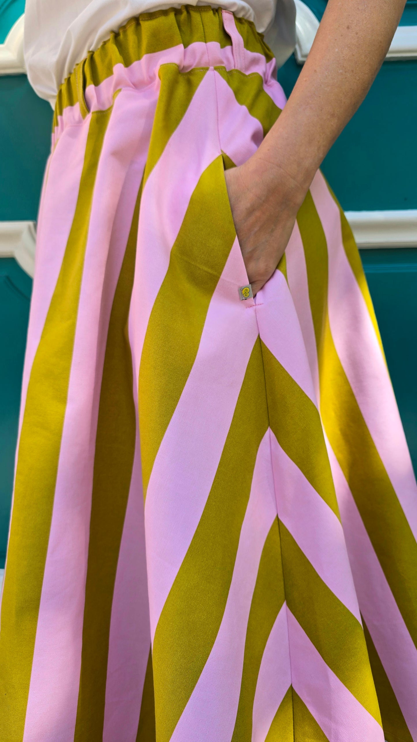 Weit schwingender Damenrock mit Blockstreifen in rosa und kiwi, seitliche Eingrifftaschen und elastischer Bund.