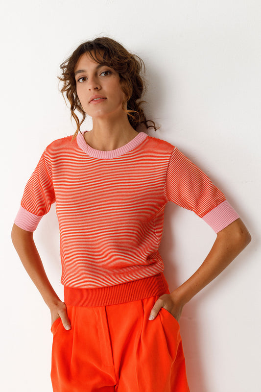 Kurzärmliges Damen Stricktop in Streifenoptik orange und rosa, mit rosa Armbündchen und Halsabschuss.