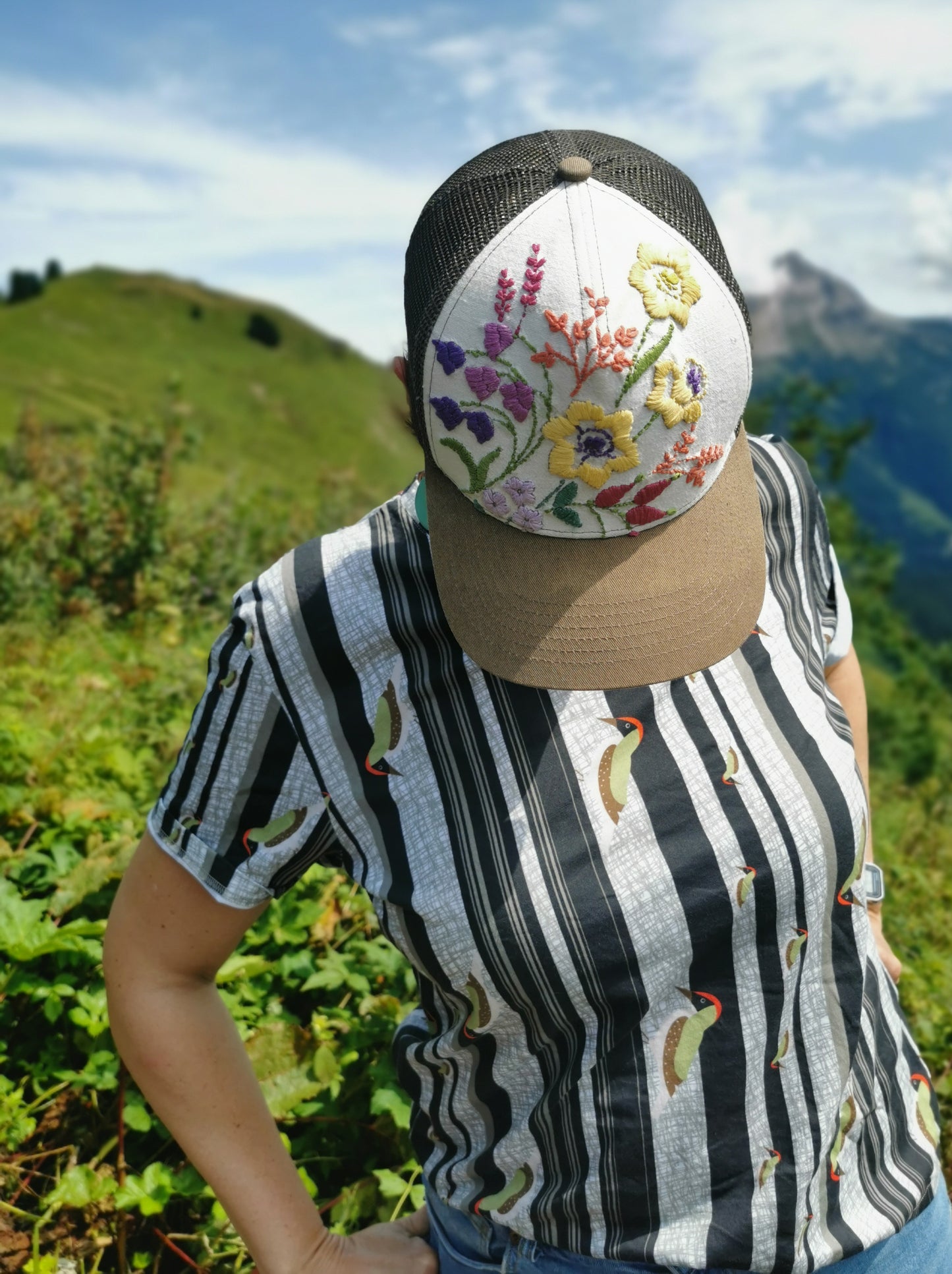 T-Shirt aus Biobaumwolle mit Streifenmuster in unregelmäßigen Abständen- die Streifen sind schwarz auf weiß und ein Grünspecht pickt Löcher in die Streifen, witzig, verspielt.