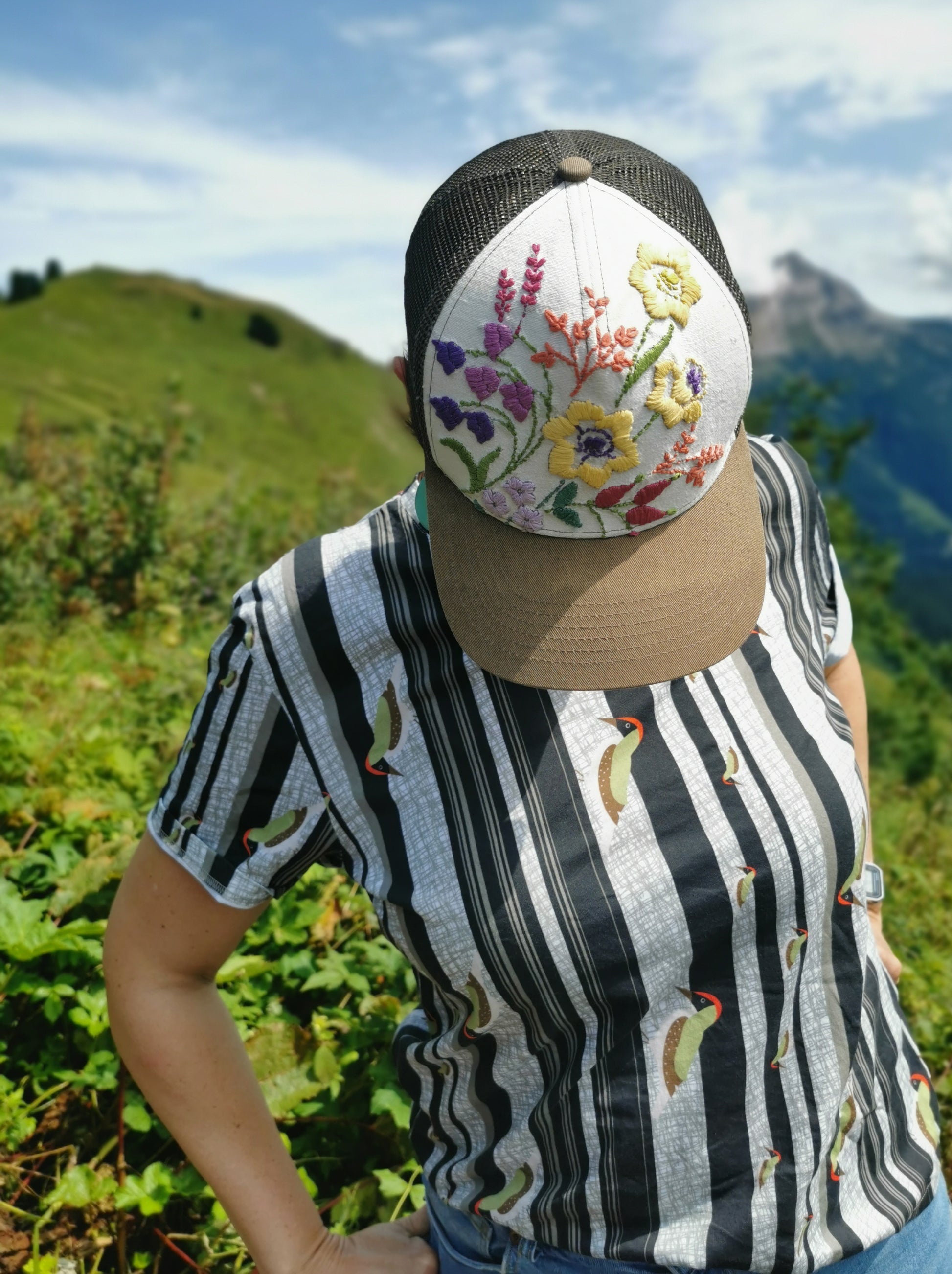 T-Shirt aus Biobaumwolle mit Streifenmuster in unregelmäßigen Abständen- die Streifen sind schwarz auf weiß und ein Grünspecht pickt Löcher in die Streifen, witzig, verspielt.