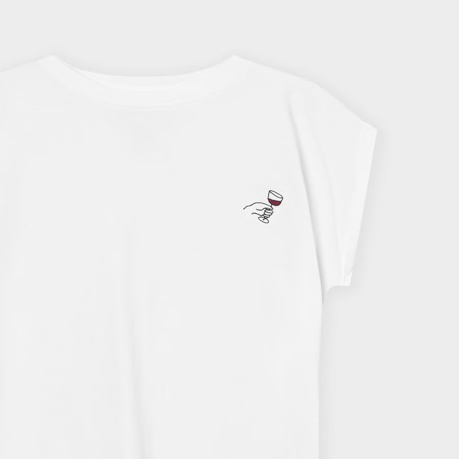 Weisses organic T-Shirt für Ladies mit kleinen Schlitzen seitlich und lässigem Ärmelaufschlag, Stickerei seitlich auf Brust mit RotweinGlas, im Begriff zuzuprosten.