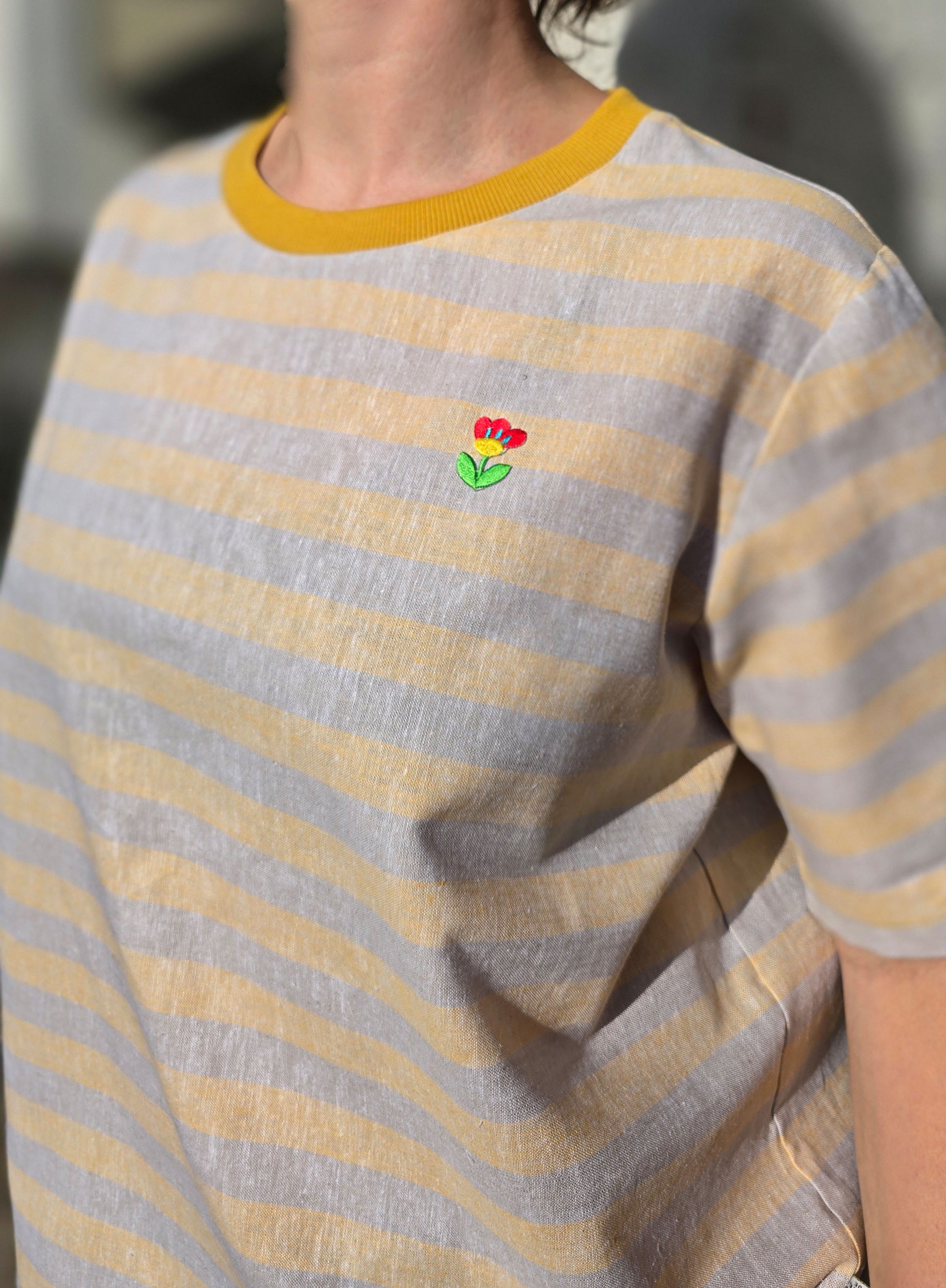 Loose Fit Shirt aus Leinen mit Baumwolle, Blockstreifen in Melange beige und -gelb mit Stickerei Blümchen Patch in rot, gelb und grün im Brustbereich.