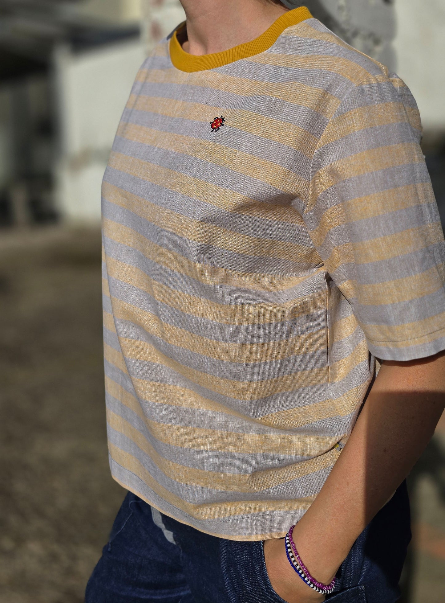 Loose Fit Shirt aus Leinen mit Baumwolle, Blockstreifen in Melange beige und -gelb mit Stickerei Marienkäfer Patch in rot und schwarz.