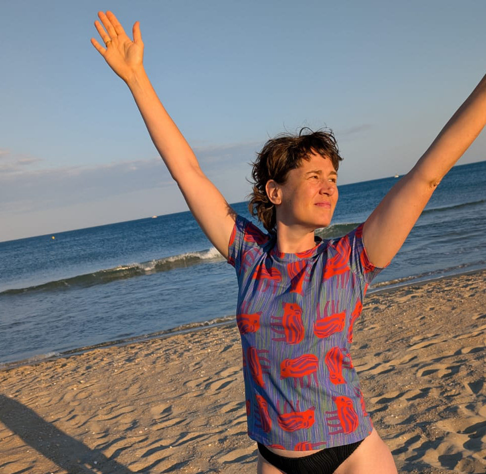 T-Shirt mit Wilder Wutz Frischling  Aufdruck in orange und gestricheltem multicolor Hintergrund.