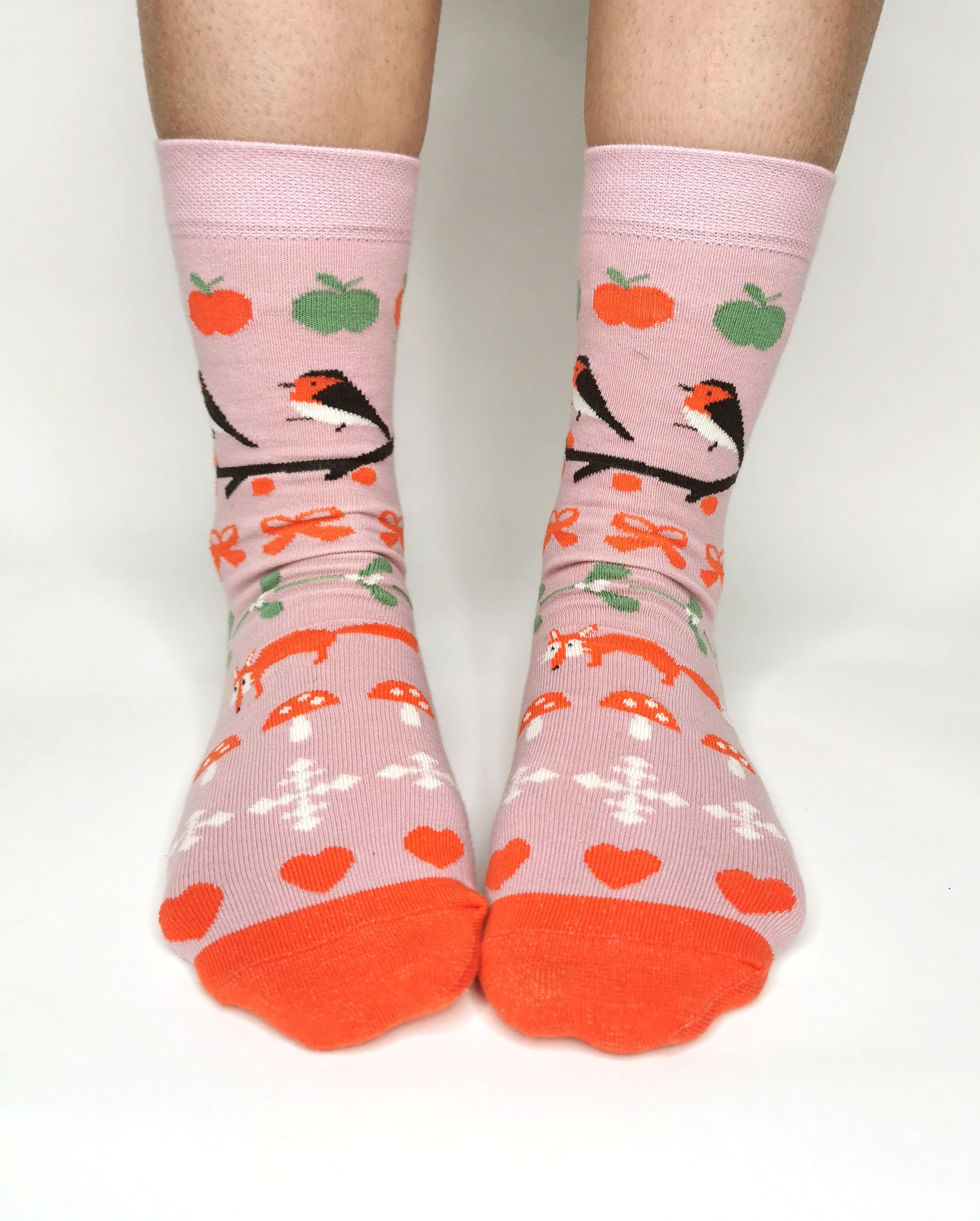 Socken in zartrosa mit Weihnachtiche Wintermotiven wie Fuchs, Fliegenpilz, Schneeflocke und Mistelzweig - romantisch verspielt.