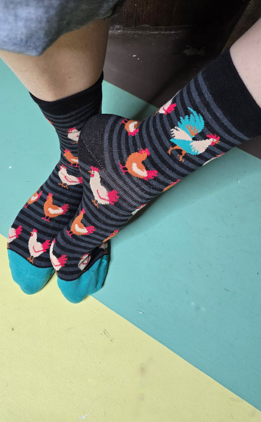 Gringete Socken in schwarz und grau mit Hühnern allover und einem farbenprächtigen Hahn.
