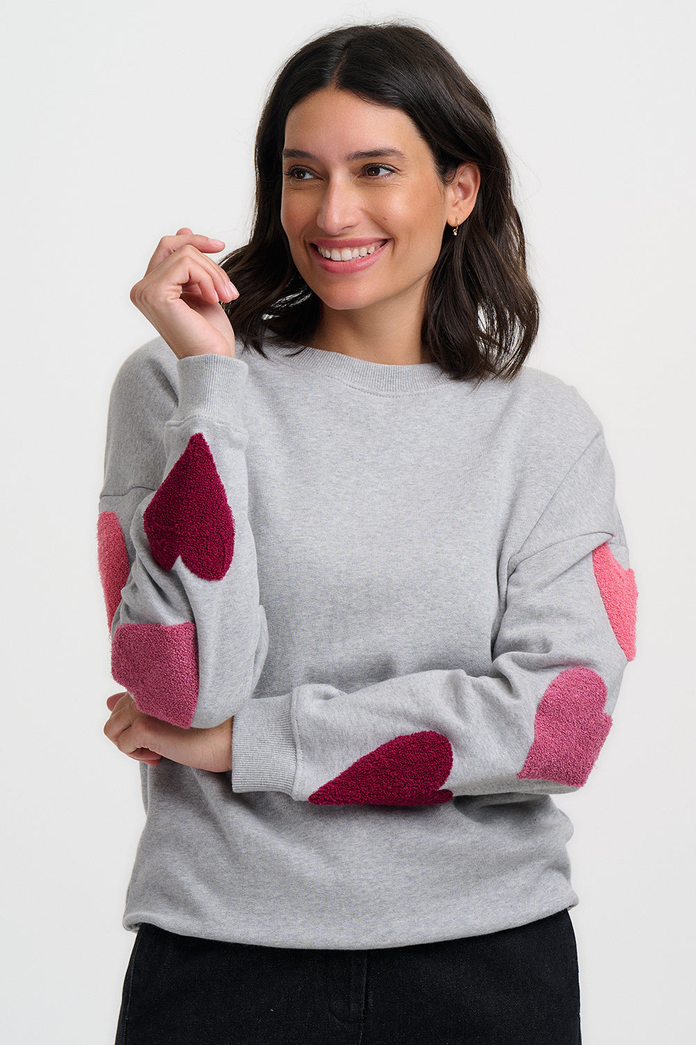Klassisches Sweatshirt in hellgrau Mélange mit langen Ärmeln und drei getufteten Herzen in unterschiedlichen pink Tönen, süss romantisch und doch sortlich.
