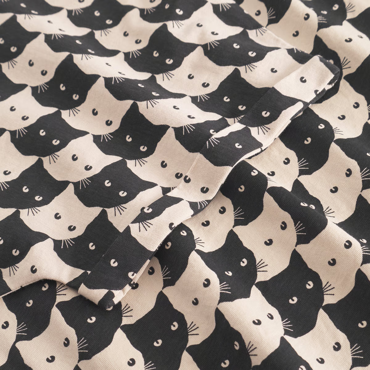 T-Shirt in Schwarz-Weiss gekacheltem Muster, bestehend aus Katzenköpfen-witzig und cool.