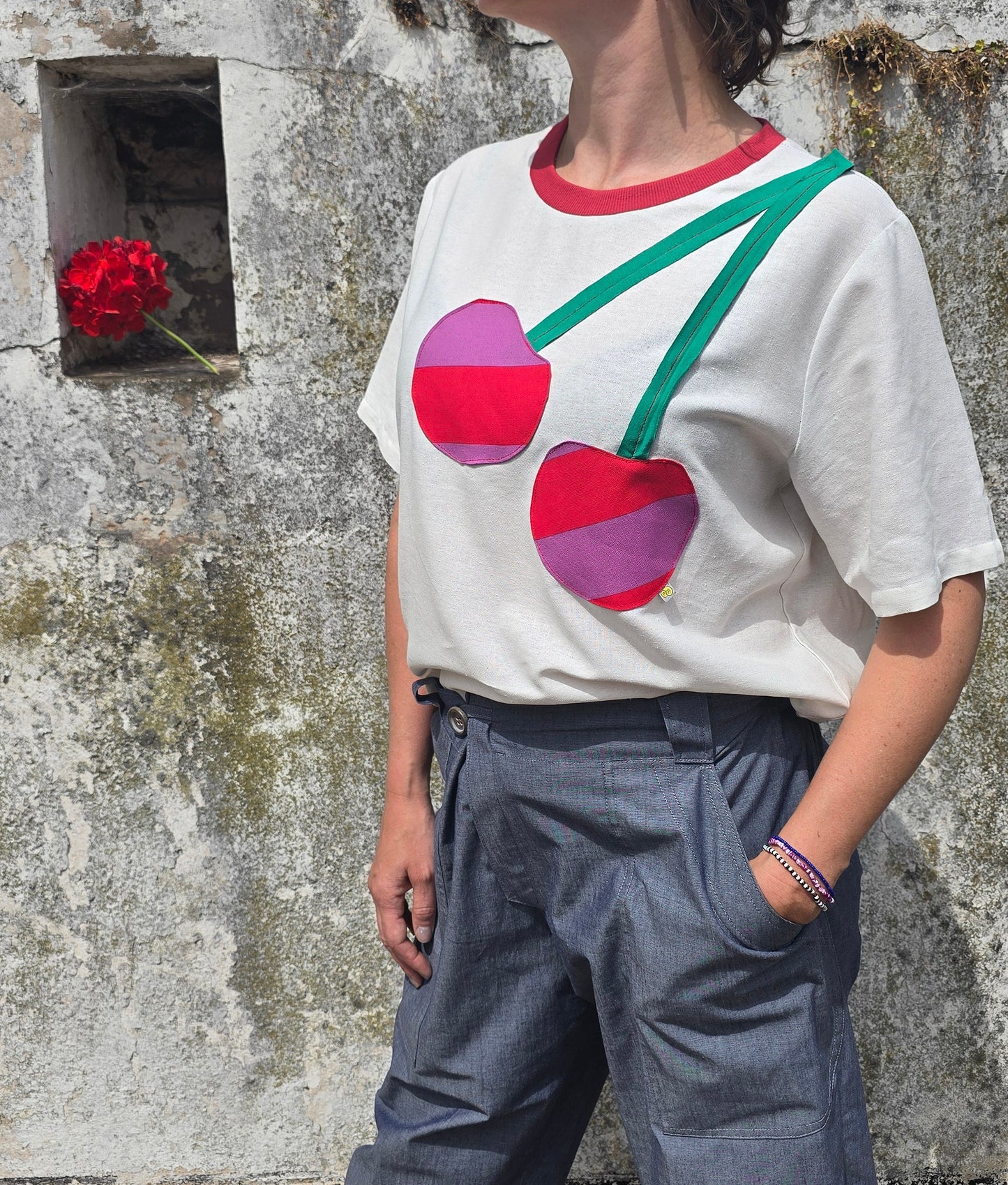 Damenshirt in Loosefit Style aus Leinenmischung in naturweiss mit seitlich über die schulter applizierte Kirsche aus gestreiftem Stoff und grünem Jersey.