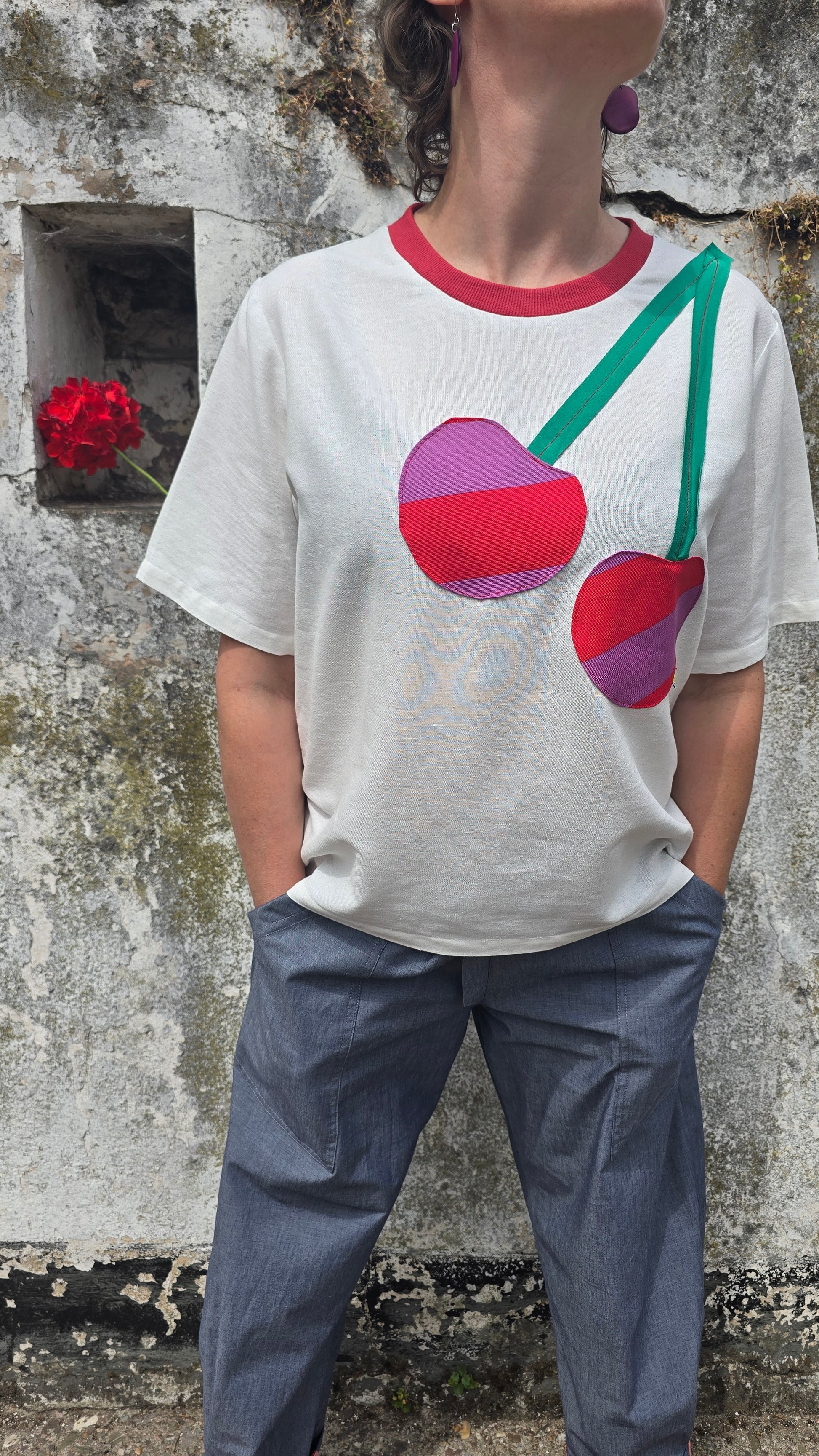 Damenshirt in Loosefit Style aus Leinenmischung in naturweiss mit seitlich über die schulter applizierte Kirsche aus gestreiftem Stoff und grünem Jersey.