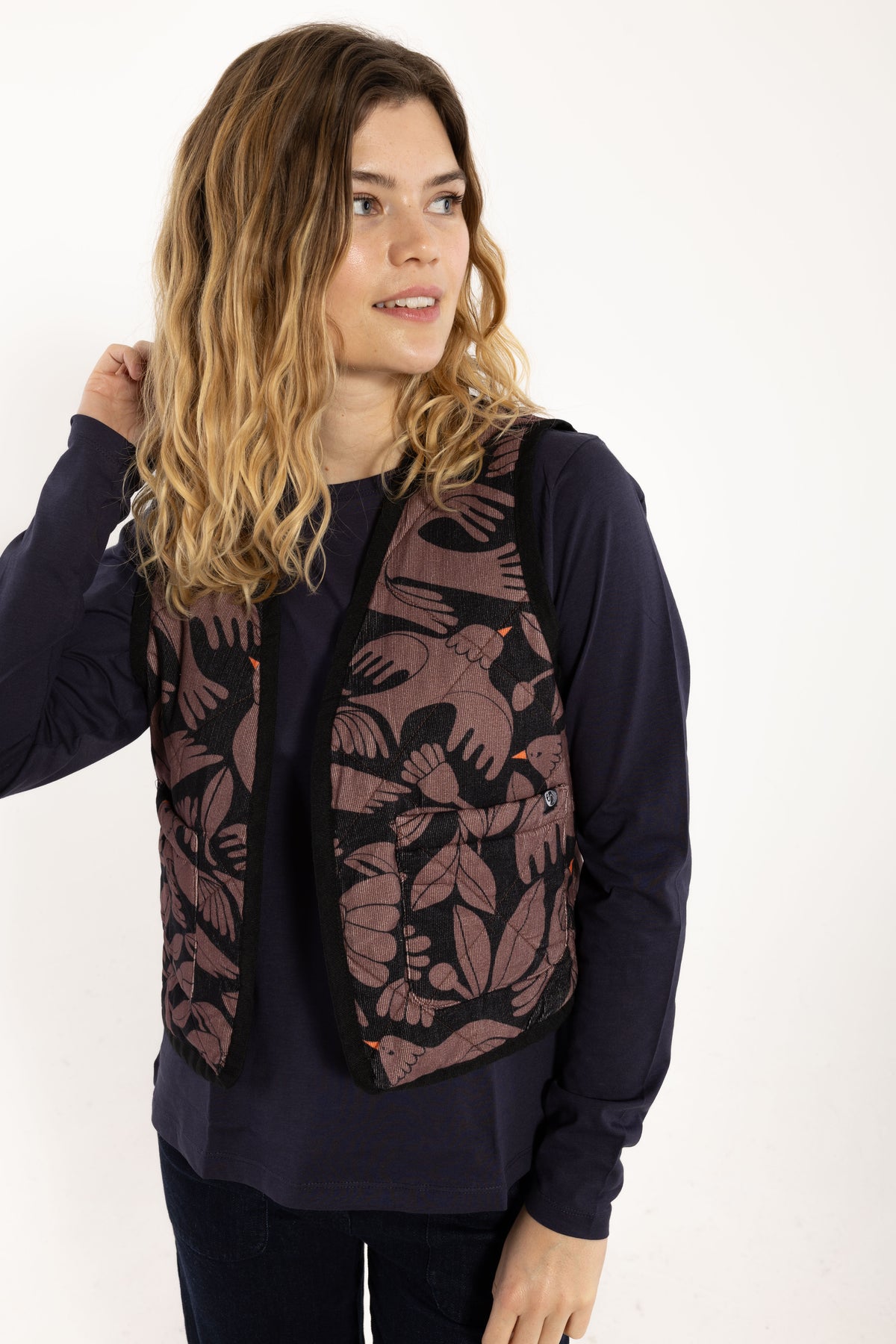 Ärmellose, wattierte Weste aus Kord mit wunderschönem Vogelprint und Blumen, gehalten in den Farben Lila und dunkelblau mit kleinsten orange Akzenten.