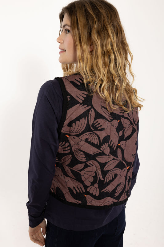 Ärmellose, wattierte Weste aus Kord mit wunderschönem Vogelprint und Blumen, gehalten in den Farben Lila und dunkelblau mit kleinsten orange Akzenten.