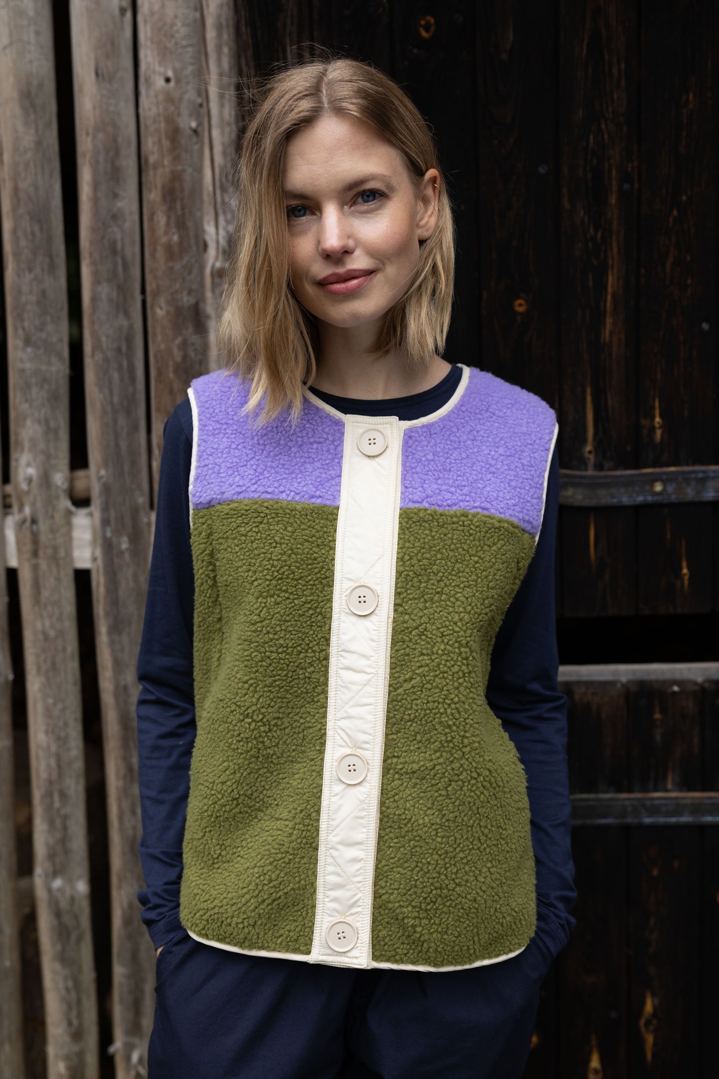 Fleece Weste im trendy Colourblock, lila und olive mit Knopfblende in Beige.