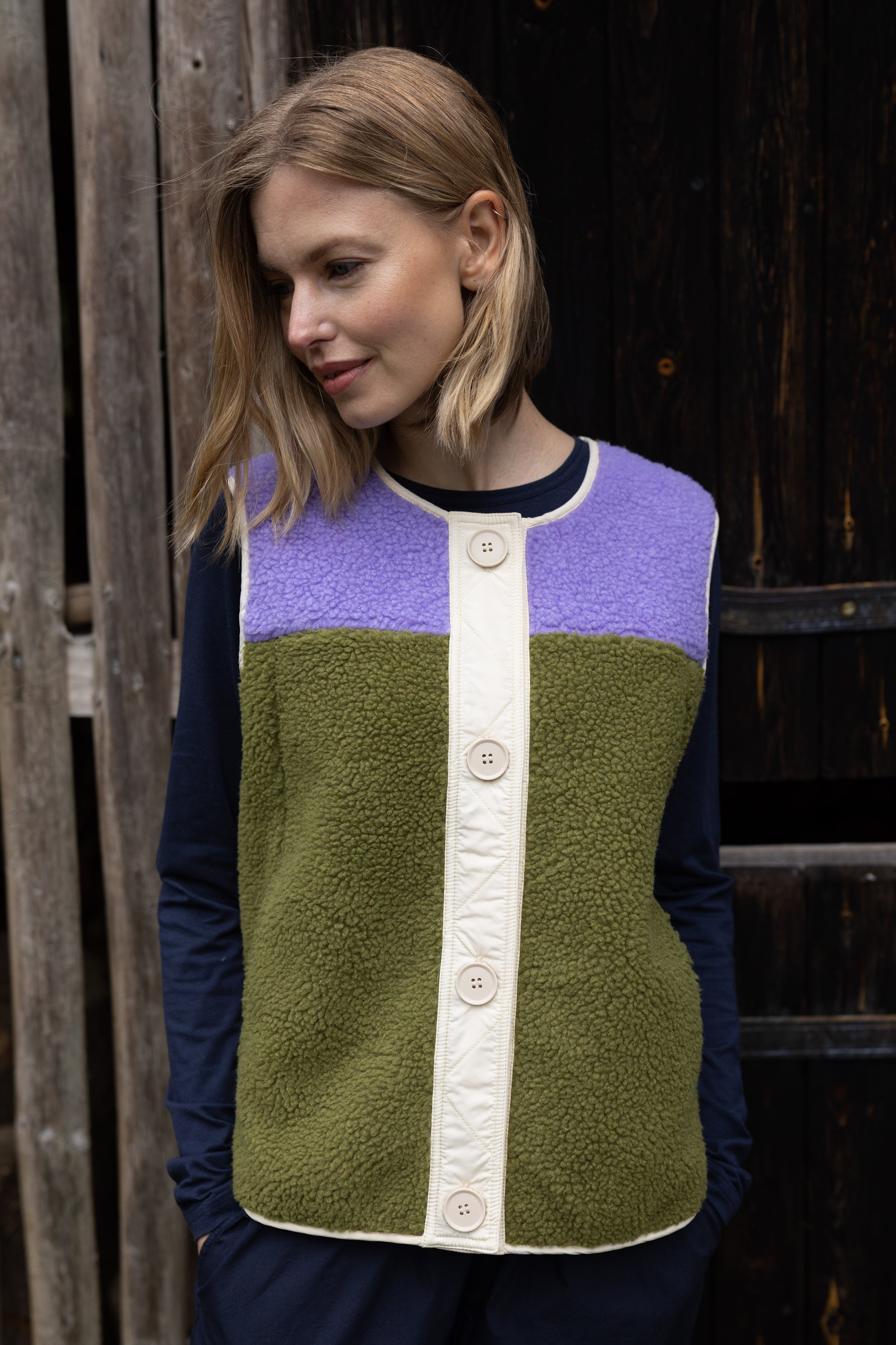 Fleece Weste im trendy Colourblock, lila und olive mit Knopfblende in Beige.