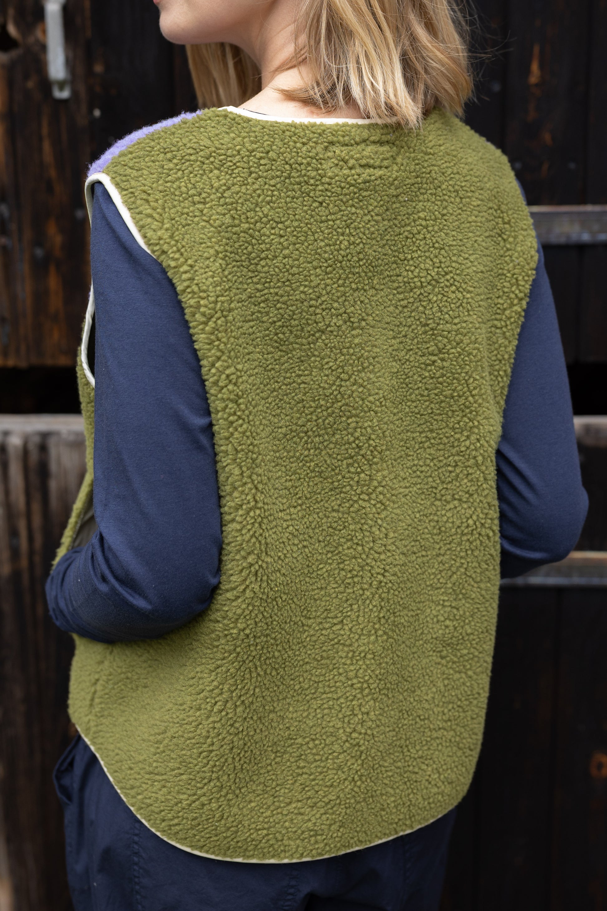 Fleece Weste im trendy Colourblock, lila und olive mit Knopfblende in Beige.