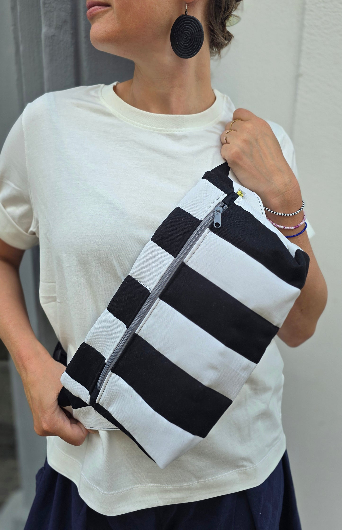 Rechteckige Handtasche oder Bauchtasche mit verstellbarer Schnalle, weich wattiert aus Canvas, fester Baumwolle mit Blockstreifen und Reißverschluss schwarz/weiss.