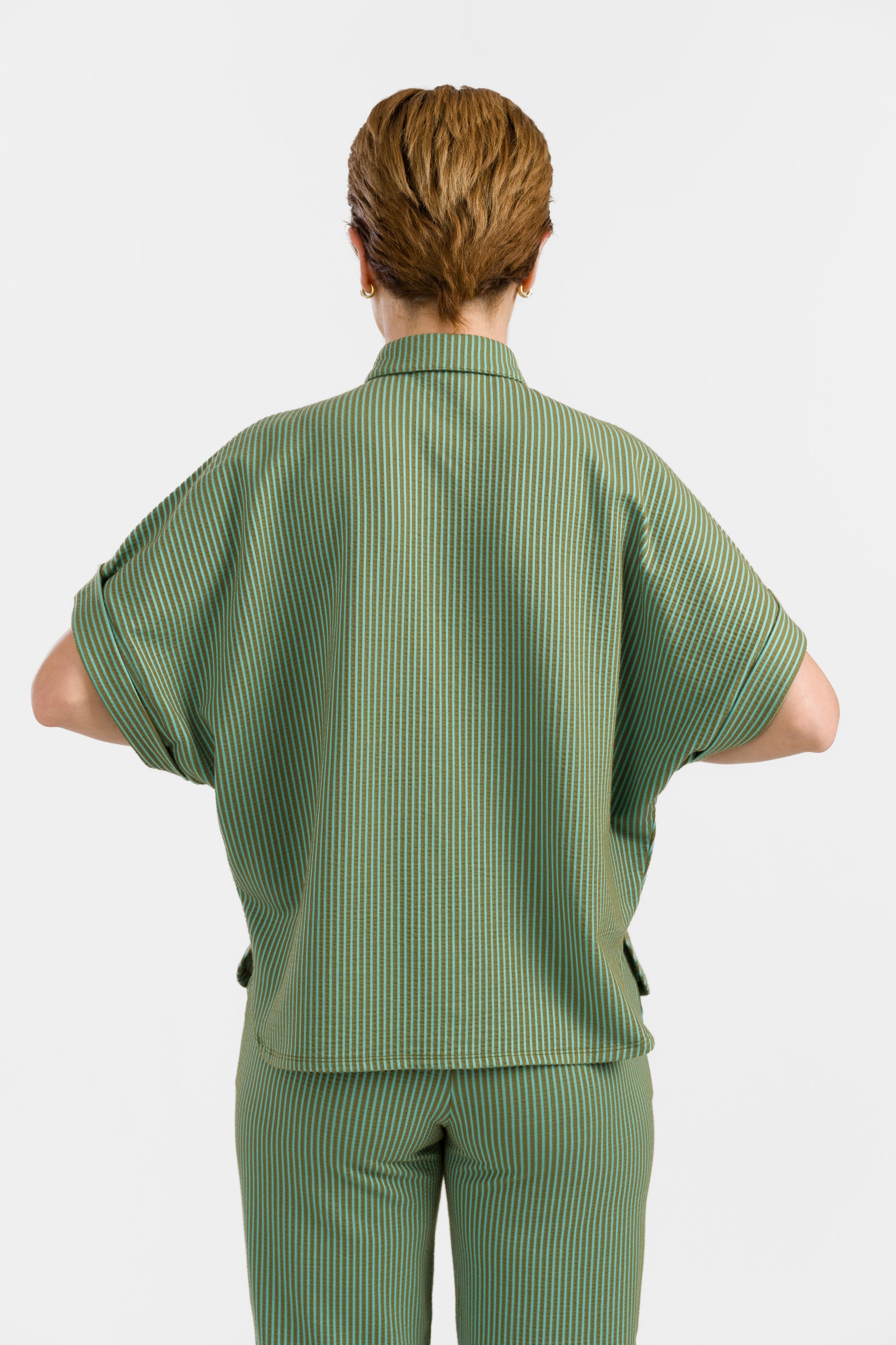 Grün-hellgrün gestreifte Seersucker Bluse in Loosefit Style mit Bubikragen und weit üerschnittenem kurzen Ärmel mit Aufschlägen- Vorne geknöpft.