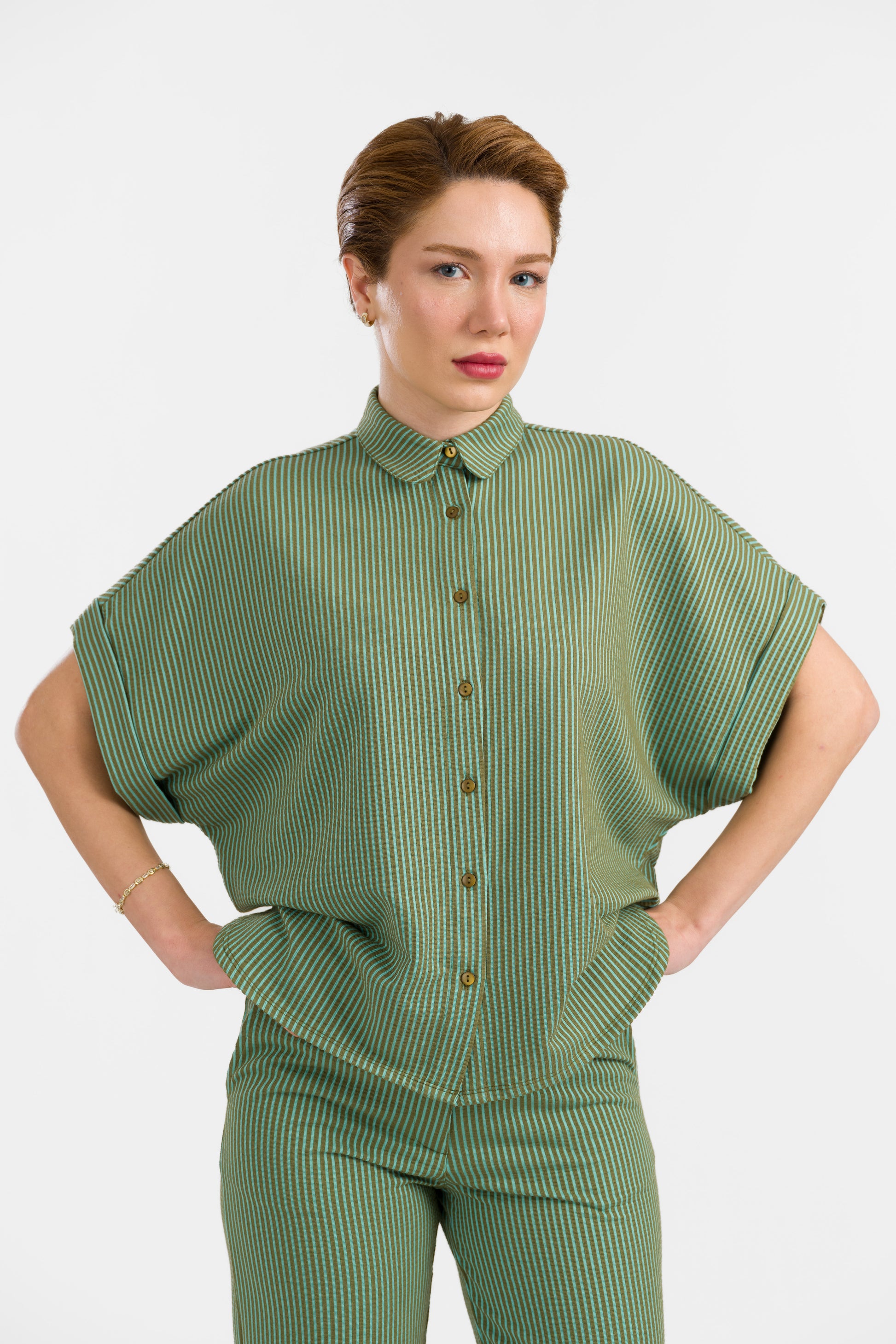 Grün-hellgrün gestreifte Seersucker Bluse in Loosefit Style mit Bubikragen und weit üerschnittenem kurzen Ärmel mit Aufschlägen- Vorne geknöpft.