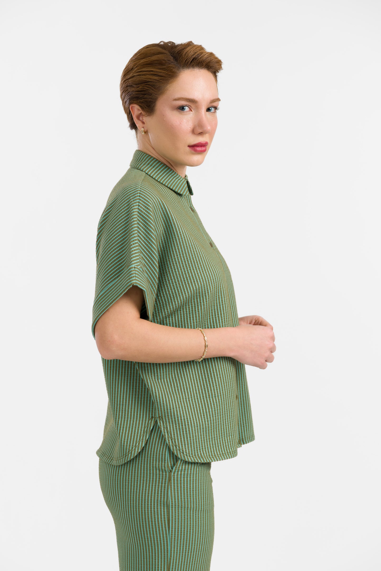 Grün-hellgrün gestreifte Seersucker Bluse in Loosefit Style mit Bubikragen und weit üerschnittenem kurzen Ärmel mit Aufschlägen- Vorne geknöpft.