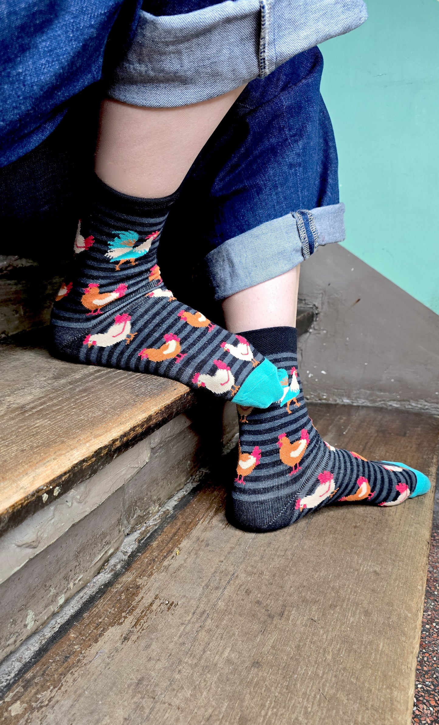 Gringete Socken in schwarz und grau mit Hühnern allover und einem farbenprächtigen Hahn.