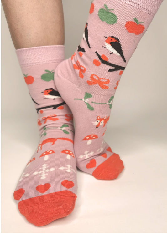 Socken in zartrosa mit Weihnachtiche Wintermotiven wie Fuchs, Fliegenpilz, Schneeflocke und Mistelzweig - romantisch verspielt.