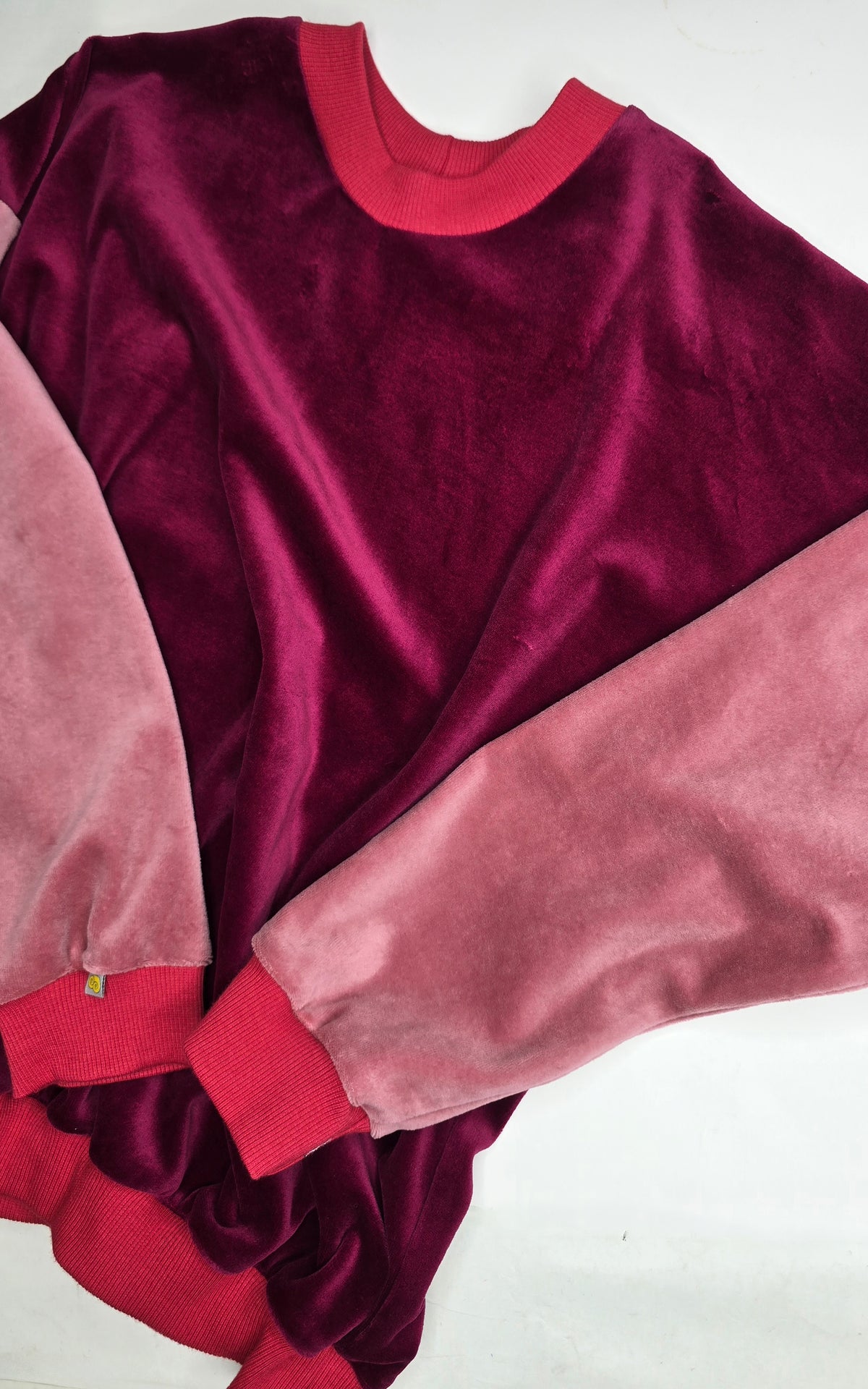 Weicher nicky Kindersweater mit rot Bündchen, rosa Ärmeln und brdeaux Korpus, Retro total.