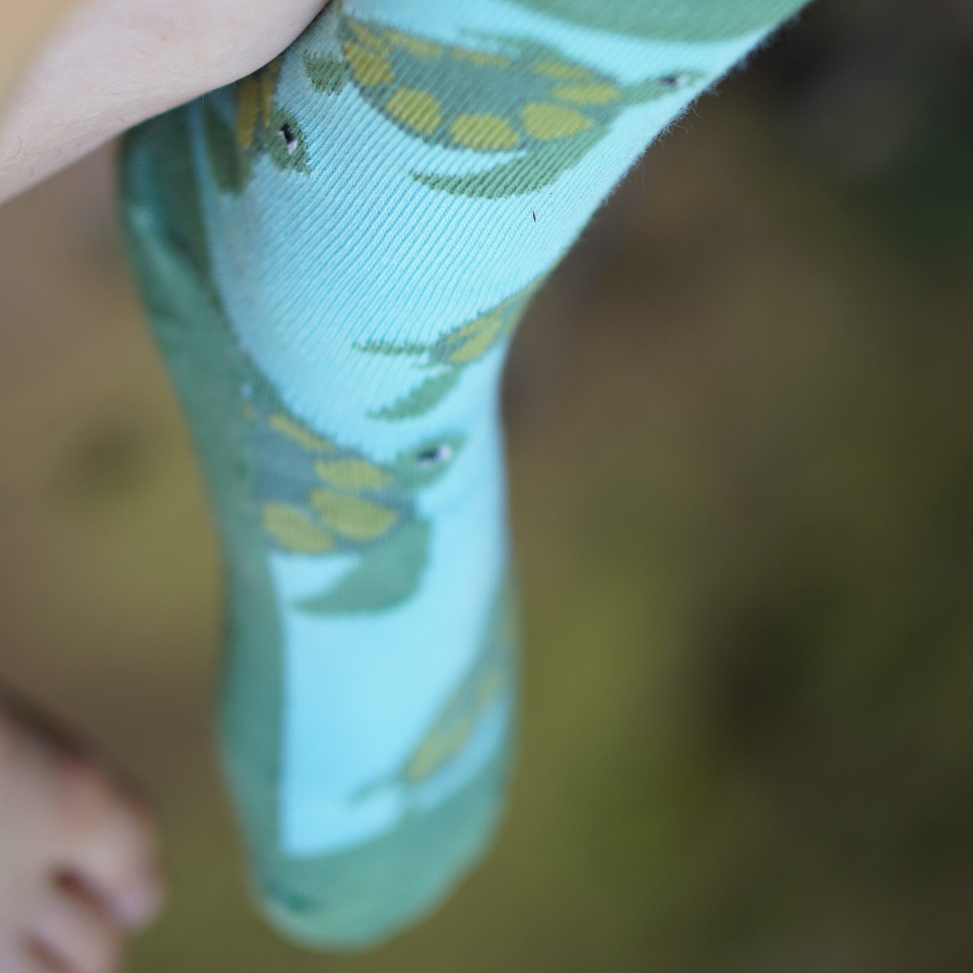 Kindersocke Tragefoto mit schoenem Schildkroetenmotiv in blau und gruen.