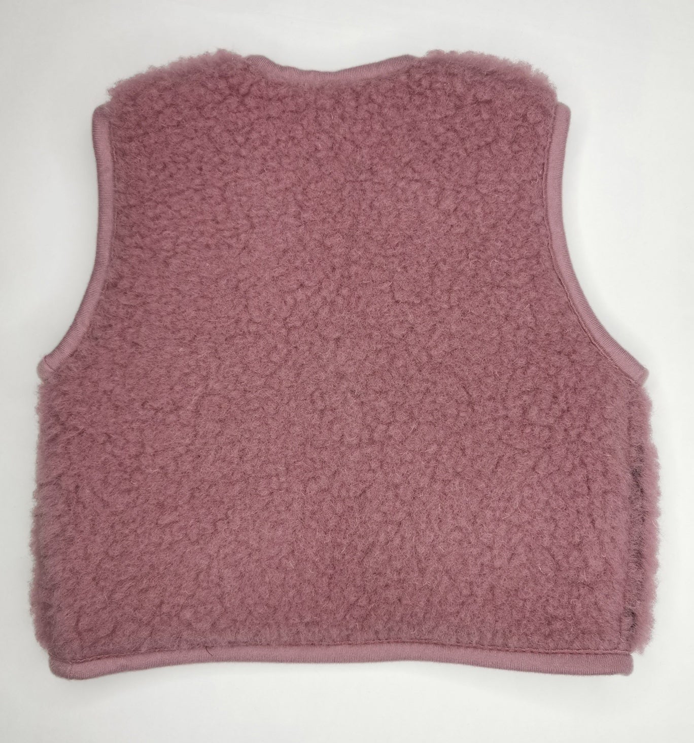 Kuschelige Baby Weste mit Druckknopf aus Wollflies in zartem rosa.