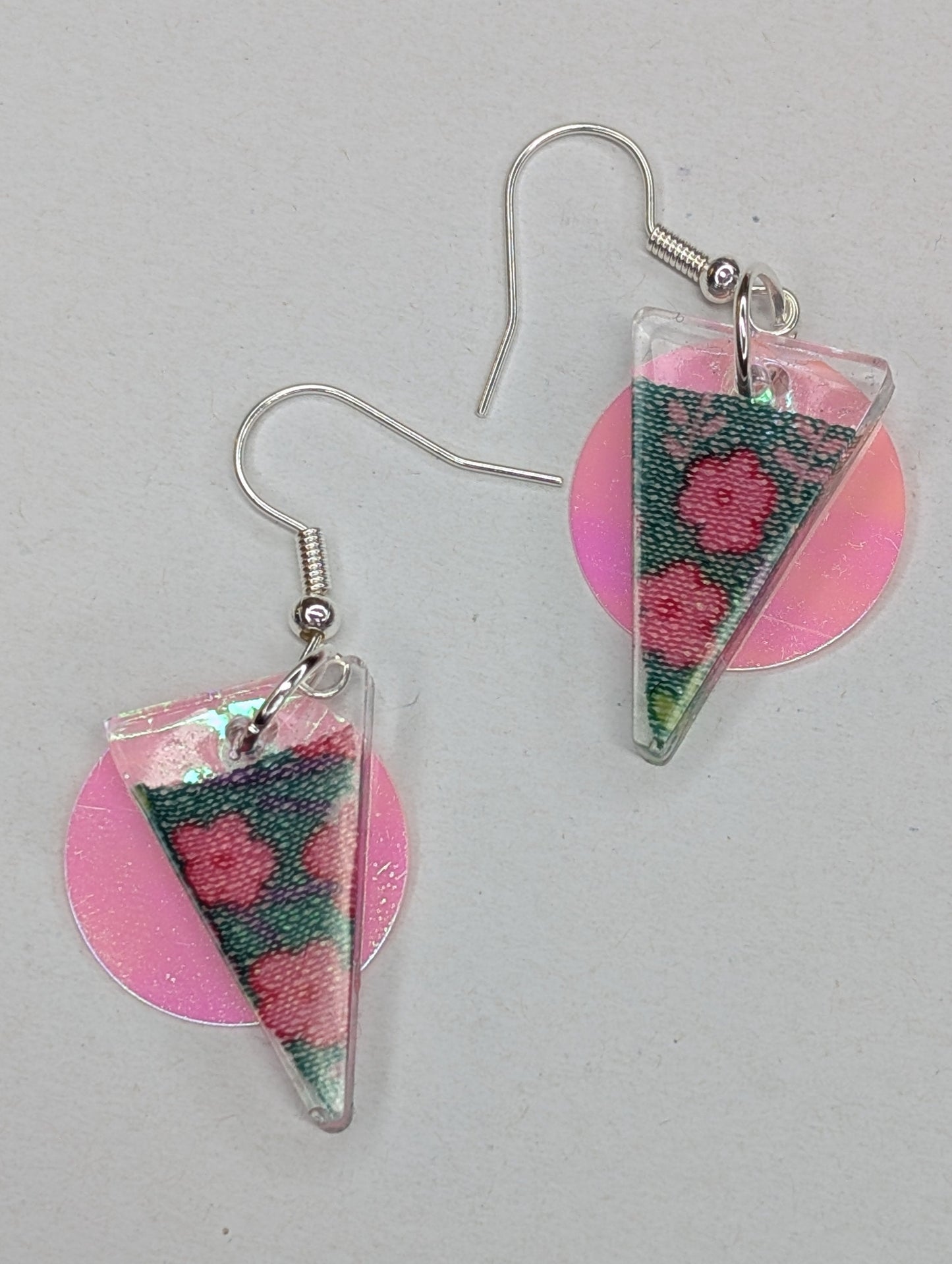 Stilvolle Ohrringe in Dreiecksform mit eingefügtem Blumenmusterstoff, in den Farben rosa und gruen.