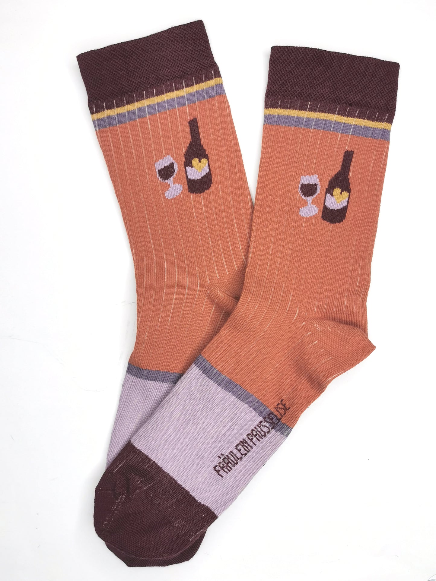 Wein Flasche un Glas auf einer zimt farbenen Socke in Ripp Strick mit colourblock Akzenten in bordeau, lila und gelb.