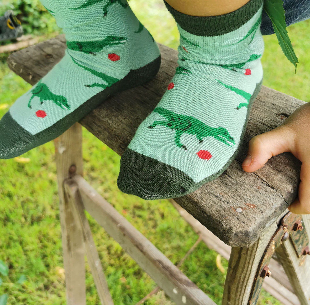 Tragefoto von den Prusselise Kindersocken mit coolem Dinomuster in gruen.