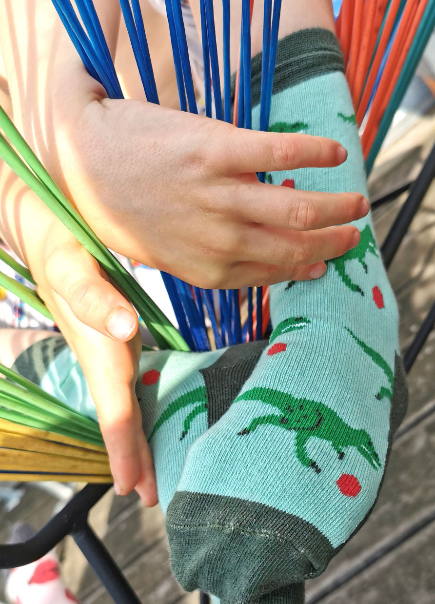 Tragefoto von den Prusselise Kindersocken mit coolem Dinomuster in gruen.