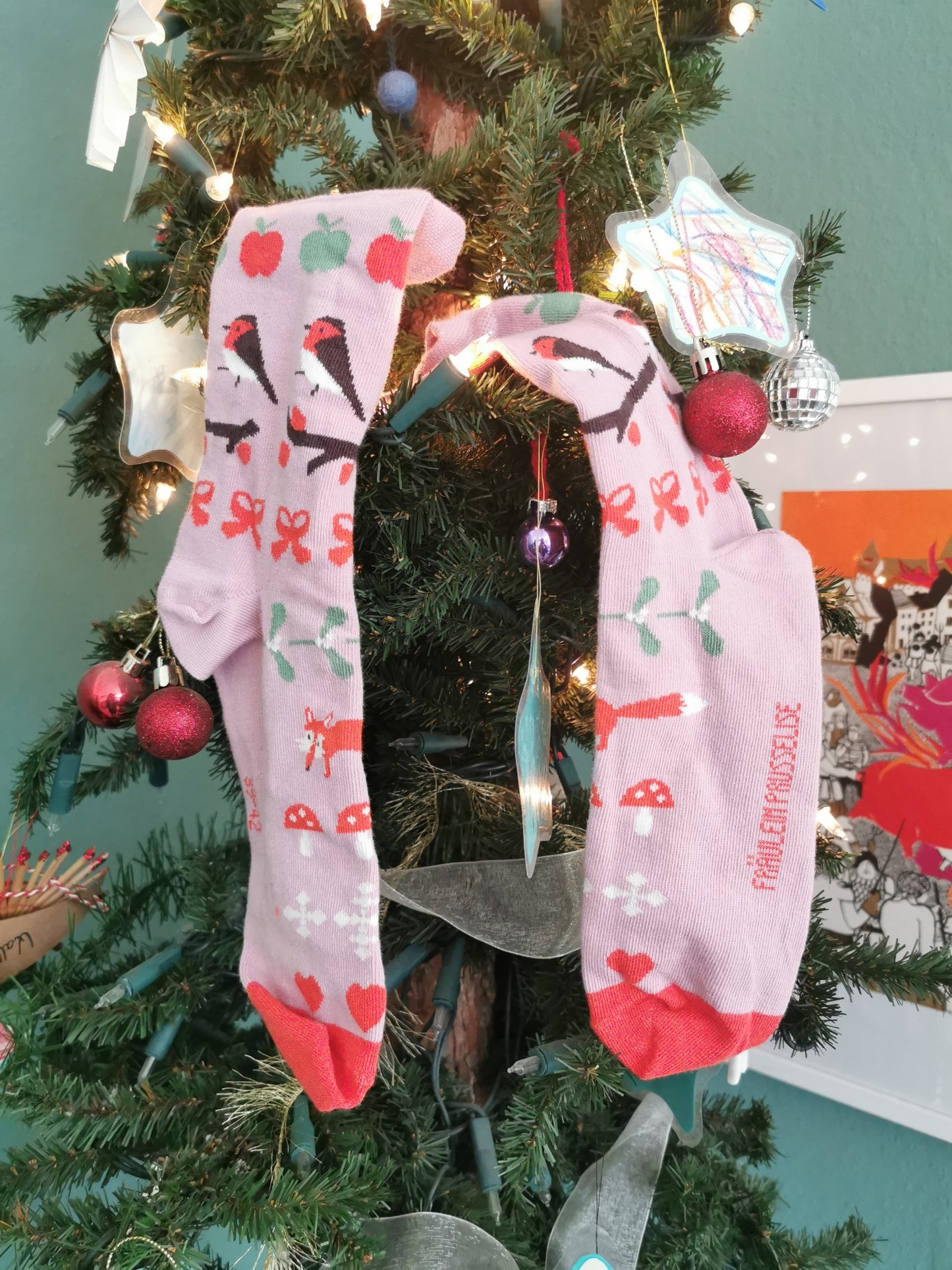 Socken in zartrosa mit Weihnachtiche Wintermotiven wie Fuchs, Fliegenpilz, Schneeflocke und Mistelzweig - romantisch verspielt.