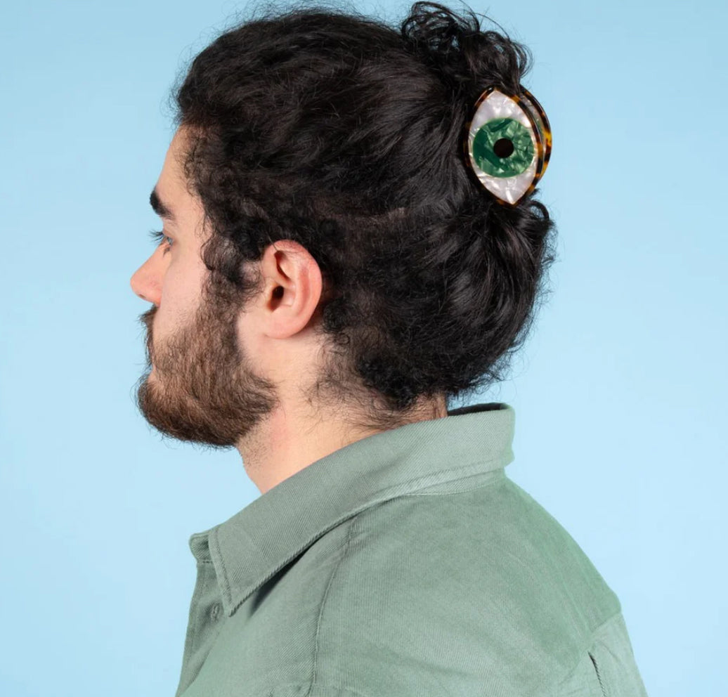 Ein Mann trägt eine Haarspange in Auge Form